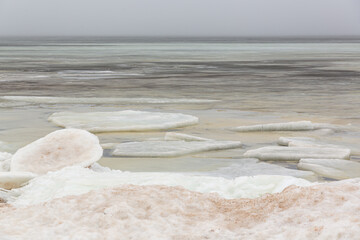 Sea view with frozen water, ice cubes and snow in foreground at the Baltic sea in February in Latvia