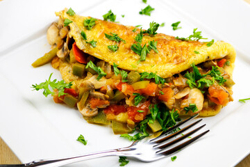 A freshly made Mexican omelette on a white plate with a fork.