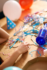 Close up of hand woman hold a glass of champagne, sleeping at table in messy room after birthday party