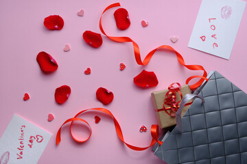 Grey paper bag, red and pink hearts and gift on white background. Valentine day concept.