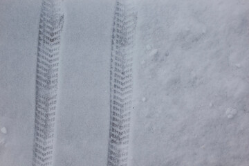 Car tire tracks in the snow.