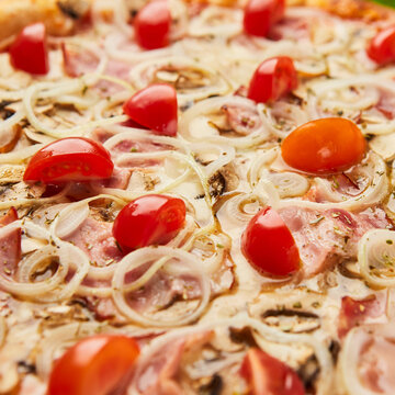 Traditional italian Pizza with ham, mushrooms and onion on green grass background