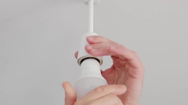 Male hands changing light bulb, electrical repair and maintenance servic