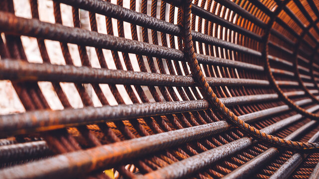 Iron on construction site. Circle Iron Bundle for making reinforcement concrete and plastic orange net. Inside view of rebar for reinforced hole in the ground. Texture