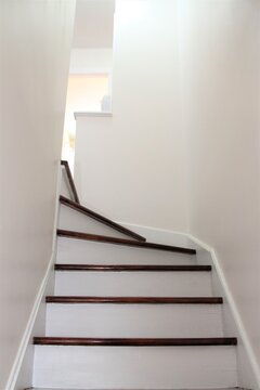 Interior modern staircase with brown stairs and white risers and walls