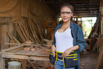 carpenter woman is working in a woodworking office.Worker Portrait asian female carpenter standing and looking at camera