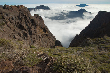 Volcanic crater covered by a sea of clouds. Caldera de Taburiente National Park and Cumbre Vieja in the background. La Palma. Canary Islands. Spain.
