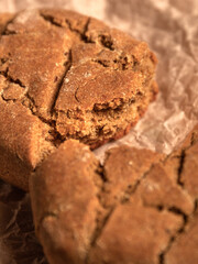 Close-up homemade bread on parchment paper on wooden table