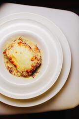 Serving delicious Italian Lasagne in a deep and round plate