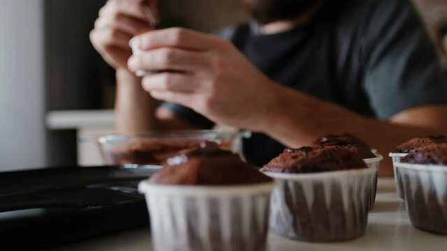 A pastry chef in the kitchen is putting chocolate in a chocolate muffin. Master class, cooking process. Step by step. Smooth focus on subject