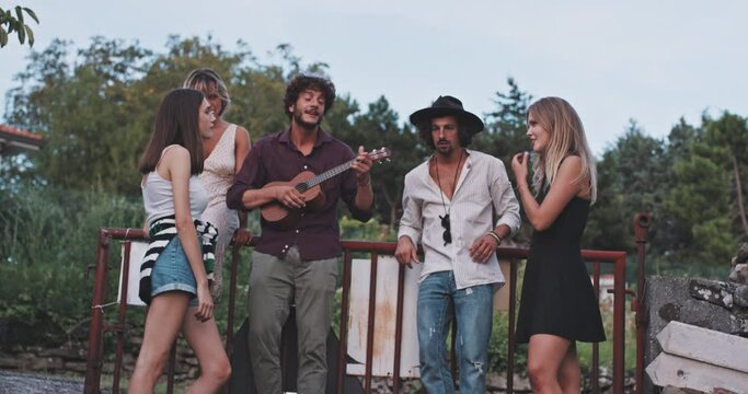 Group of friends playing ukulele and having a great time 
