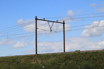 Fototapeta premium Embankment with catenary, blue sky in the background 