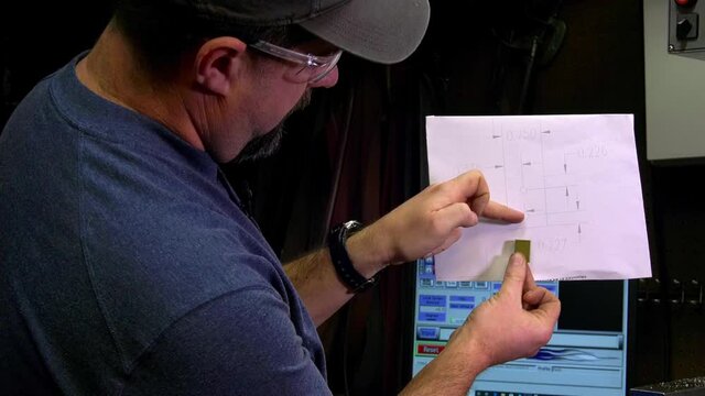 Operator explaining to someone else what he did based on a pattern to created this brass block
