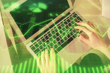 Double exposure of woman hands working on computer and forex chart hologram drawing. Top View. Financial analysis concept.