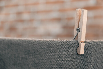 One wooden clothespin holding clothes on a rope. Drying on a wire, gently moved by the wind, housework concept. Copy, empty space for text