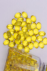 Selective focus image of Cod liver oil capsules bottle containing cod liver capsules with some spill over