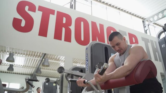 Motivating shot of an athlete doing biceps workout ath the gym
