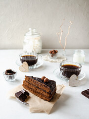 Piece of chocolate cake and two cups of coffee on the table
