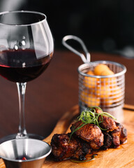 glass of wine, a piece of meat and fried potatoes