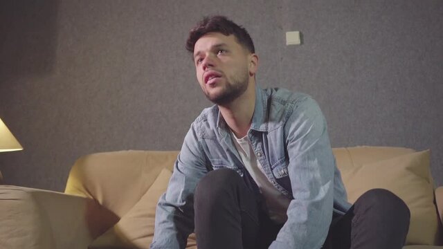 beautiful boy ties his winter shoes on a carpet in living room slow motion
