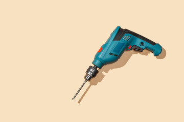 Cordless battery drill on the yellow background view from top.