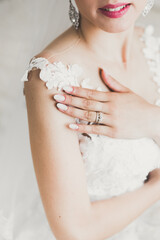 Gorgeous bride in robe posing and preparing for the wedding ceremony face in a room