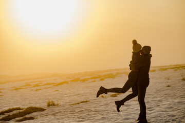Liebespaar bei Sonnenuntergang im Schnee