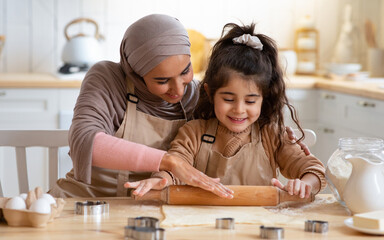 Muslim Mom Showing Her Little Daughter How To Roll Dough For Cookies