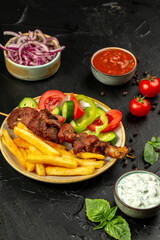 Kebap or shashlik and french fries and fresh vegetables
