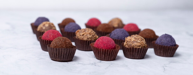 colored homemade energy balls - truffles made of cocoa, blueberry and beetroot powder