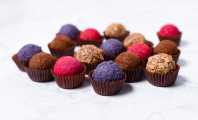 colored homemade energy balls - truffles made of cocoa, blueberry and beetroot powder