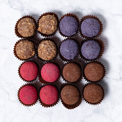 colored homemade energy balls - truffles made of cocoa, blueberry and beetroot powder
