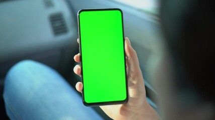 Close up of a woman's hand holding a mobile telephone with a vertical green screen in car chroma key smartphone technology cell phone street touch message display hand - Powered by Adobe