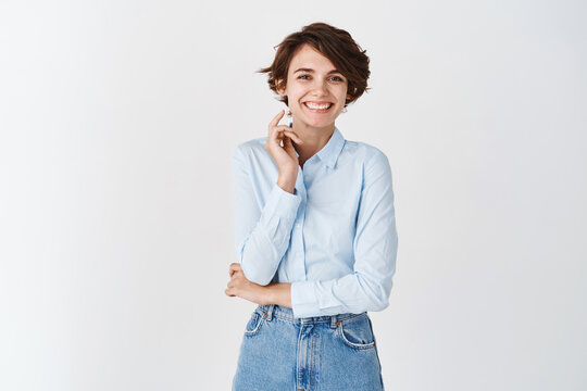 Image of beautiful caucasian woman in blue shirt smiling, looking happy, standing on white background