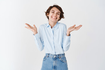 Portrait of cheerful smiling woman, shrugging and laughing flattered, being praised, receive...