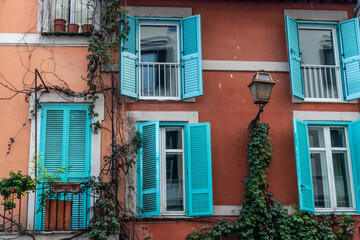 Fototapeta na wymiar Italian house with cool stylish blue teal green windows. classic.