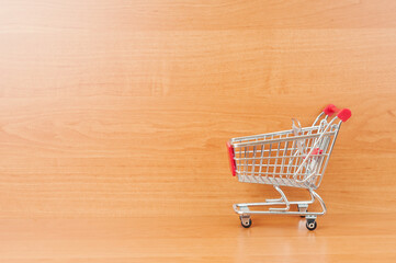 Shopping cart close up on wooden background