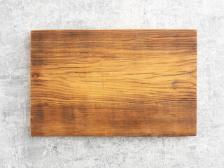 Brown wooden cutting board on white concrete background