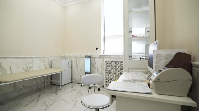 Interior of a medical cabinet at the hospital. Action. Empty medical room with couch for patients and medical equipment.
