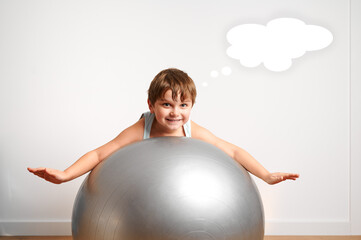 child lying on a fitness ball. drawn thoughts
