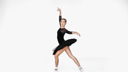 Obraz premium elegant ballerina in tutu skirt and pointe shoes dancing on white background