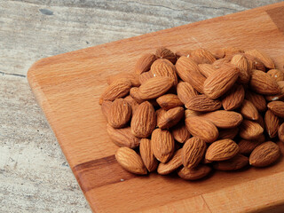Almond in a bowl on wooden background with copy space