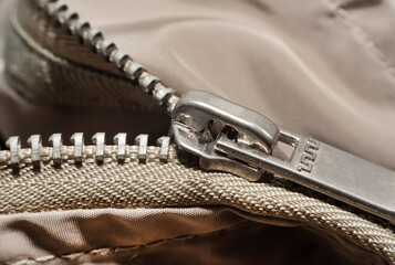 The lock with a zipper is close-up on the clothes of gray color. Zipper with lock © Gudman