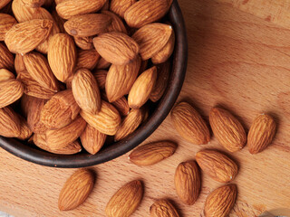 Almond in a bowl on wooden background with copy space