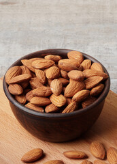 Almond in a bowl on wooden background with copy space