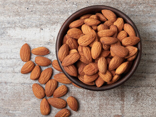 Almond in a bowl on wooden background with copy space