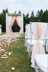 Transparent stylish plastic chairs. Luxury decor for the white wedding ceremony.