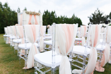 Transparent stylish plastic chairs. Luxury decor for the white wedding ceremony.