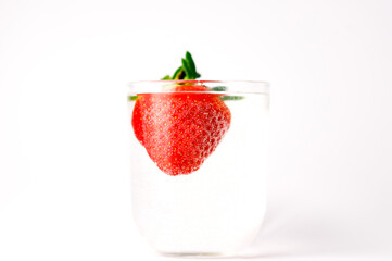 Strawberries in grall of water on white background. Advertising cocktails. Juicy fruits under water. Being shot as they submerged under water. A healthy form of product promotion.