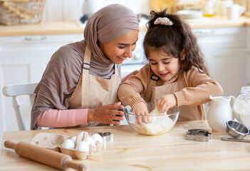 Obraz na płótnie Canvas Caring Muslim Mom Teaching Her Little Daughter How To Make Dough